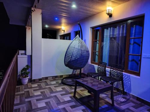a room with two chairs and a large vase on a porch at The Blissful Escapes !!! in Dharampur