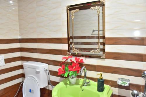 a bathroom with a sink and a mirror and a toilet at The Blissful Escapes !!! in Dharampur