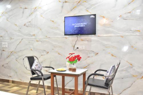 a room with three chairs and a table with a tv on a wall at The Blissful Escapes !!! in Dharampur