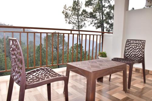 a table and two chairs on a balcony at The Blissful Escapes !!! in Dharampur