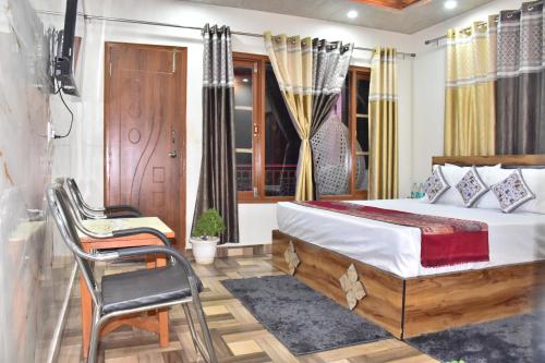 a bedroom with a bed and a chair and a window at The Blissful Escapes !!! in Dharampur