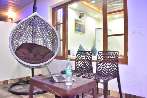 a room with a chair and a table with a laptop at A Greenwoods Hotel in Solan