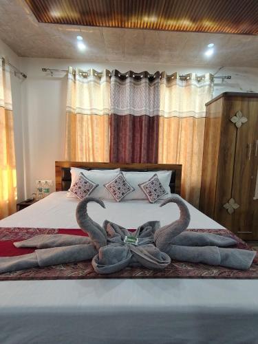 a bed with two swans made out of towels at A Greenwoods Hotel in Solan