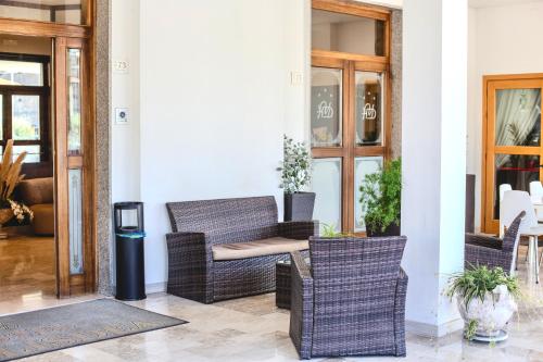 a patio with wicker chairs and a trash can at Hotel Vallisdea in Sala Consilina
