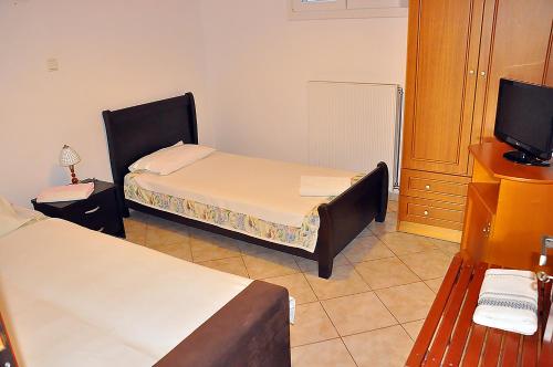 a small room with two beds and a television at Studios Kostas & Despina in Lidia