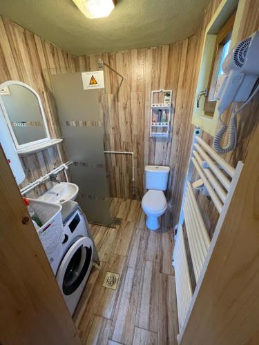 a small bathroom with a toilet and a washing machine at Villa 80 Kodra e Diellit in Tetovo
