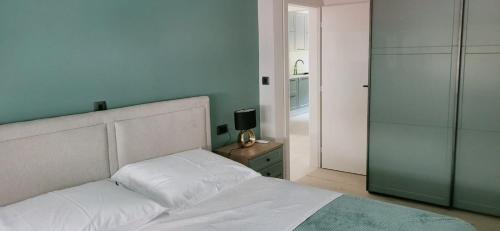 クニンにあるApartman Fortisの白いベッドと鏡のある寝室