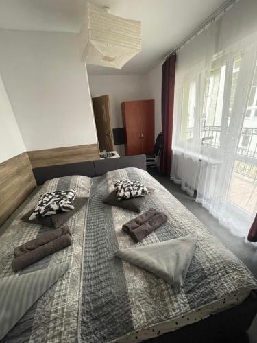 a bedroom with a large bed with pillows on it at Antonina ***PensjonPrzyKortach*** in Szczawno-Zdrój
