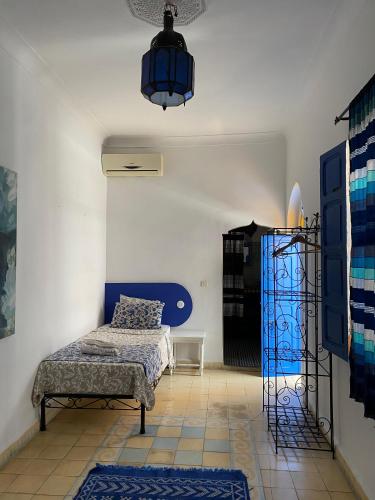 a bedroom with a bed and a chair in a room at Riad Safi médina in Safi