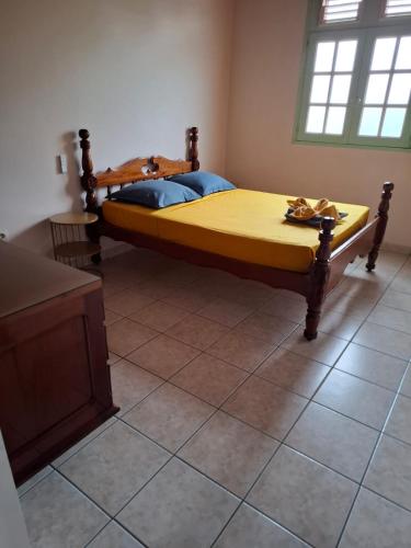 a bedroom with a large bed with a yellow mattress at Haut de Villa T3, convivial à la campagne in Saint-Joseph