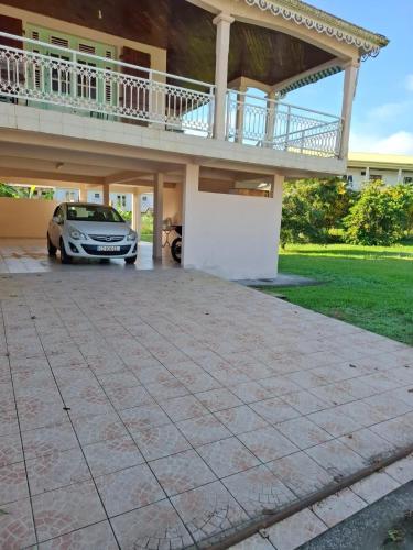a car parked in front of a house with a balcony at Haut de Villa T3, convivial à la campagne in Saint-Joseph
