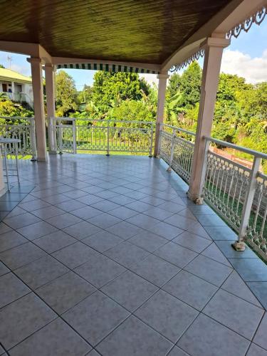 a porch with a tile floor and a railing at Haut de Villa T3, convivial à la campagne in Saint-Joseph
