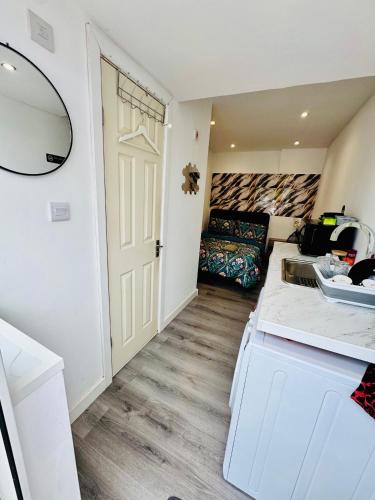 a room with a sink and a room with a couch at Enjoy the comfort at self-contained studio with free Parking - near Luton airport in Luton
