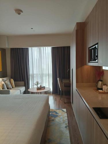 a hotel room with a bed and a living room at Novotel Manila Residence Hotel by Jolly Luxe Suites at Acqua in Manila