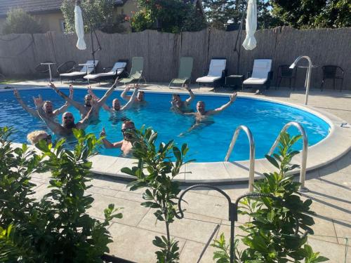 a group of people are in a swimming pool at Vila Boska Palic in Palić