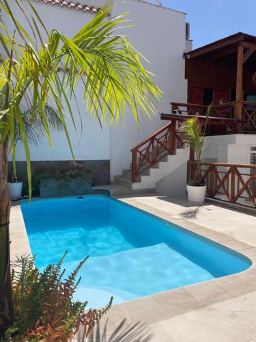 a blue swimming pool in a backyard with plants at La Villa del Sastre in Vélez-Málaga