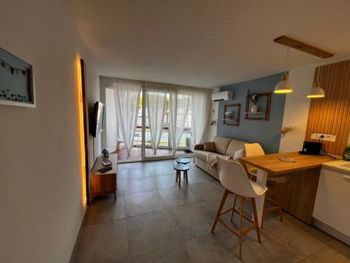 ein Wohnzimmer mit Sofa und Tisch in der Unterkunft La Bulle Marine in La Grande-Motte