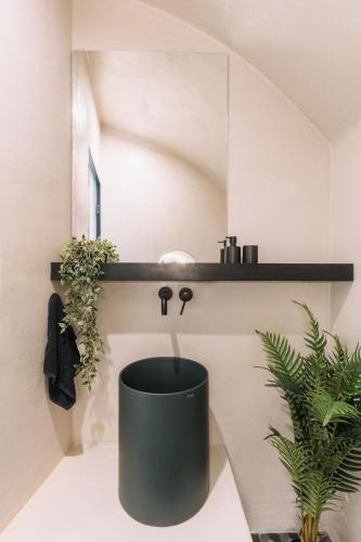 a bathroom with a black toilet and a sink at Noir Cave Villa with private Jacuzzi and Sunset Terrace in Pirgos