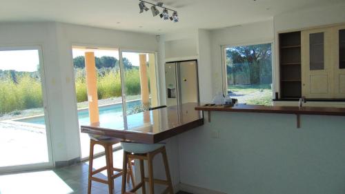 a kitchen with a counter and two stools in it at La Pampa au Mas des Issarts in Saint-Jean-de-Fos
