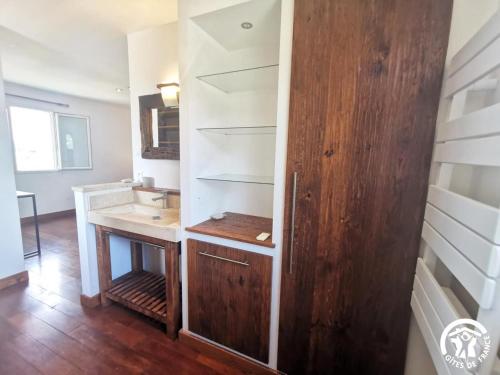 a bathroom with a sink and a wooden door at La Pampa au Mas des Issarts in Saint-Jean-de-Fos