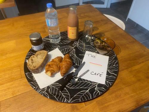 a table with a plate with pastries and bottles of water at La Pampa au Mas des Issarts in Saint-Jean-de-Fos