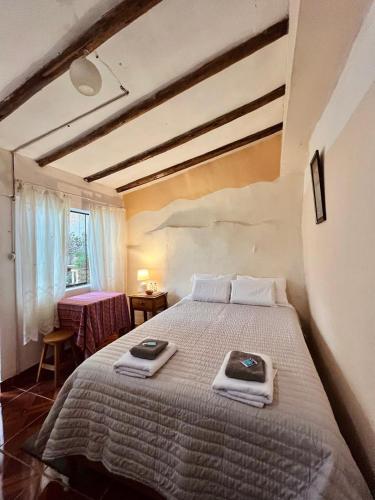 a bedroom with a large bed with towels on it at La Huerta Refugio in Urubamba
