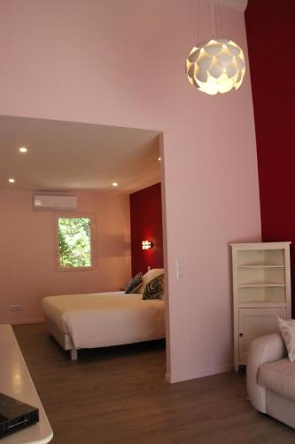 a bedroom with a bed and a couch at Les Chambres du Hameau in Gordes