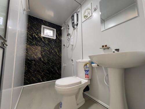 a bathroom with a toilet and a sink at Leopard Inn Wilpattu in Ilavankulam