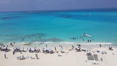 a group of people on a beach with umbrellas at مرسي مطروح in Marsa Matruh