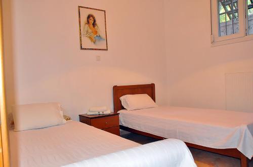 a room with two beds and a picture on the wall at Studios Kostas & Despina in Lidia