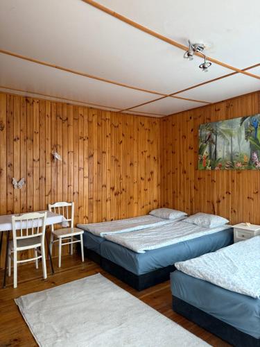 two beds in a room with a table and chairs at WCZASY 90s in Gdańsk