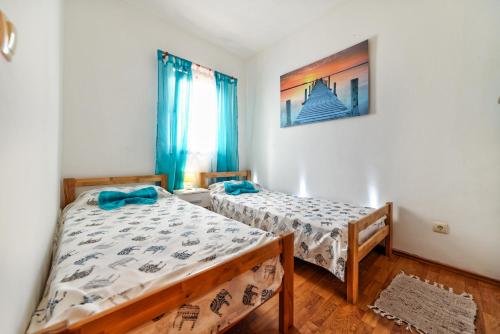 a bedroom with two beds and a picture on the wall at Holiday Home & Apartments Primavera in Pula