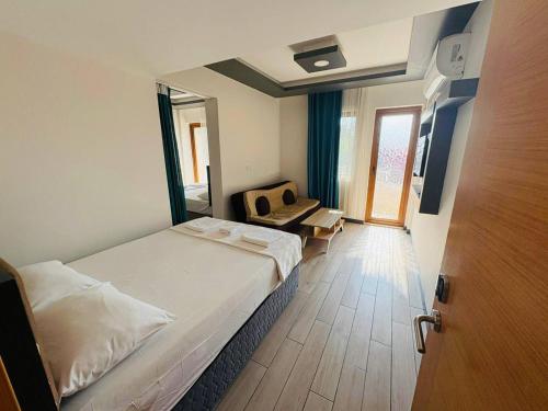 a bedroom with a bed and a chair and a door at Sarıgerme Apart otel in Ortaca