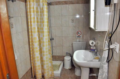 a bathroom with a sink and a toilet and a shower at Studios Kostas & Despina in Lidia