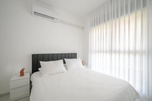 a bedroom with a white bed and a large window at Most perfect 4-BDR with jacuzzi BY MadrigalRentals in Qiryat Ata