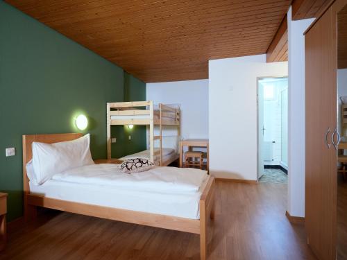 a bedroom with a bed and a wooden ceiling at Löwen Lodge in Seelisberg