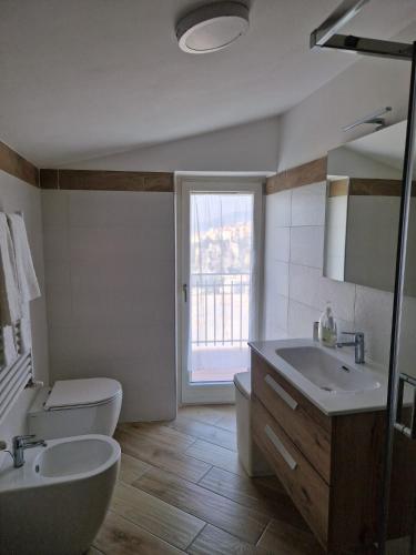 a bathroom with a sink and a toilet and a window at Lodge Rosa in Agropoli