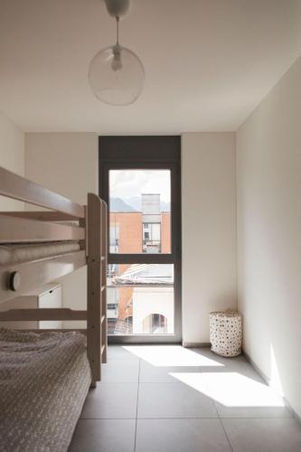a bedroom with a bed and a large window at Casa Solduno - App 1220 in Solduno