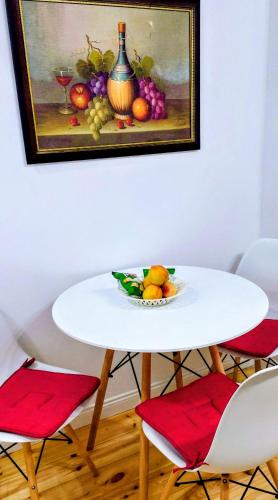 a painting of a table with a bowl of fruit at Sweet Home Aria in Çorovodë