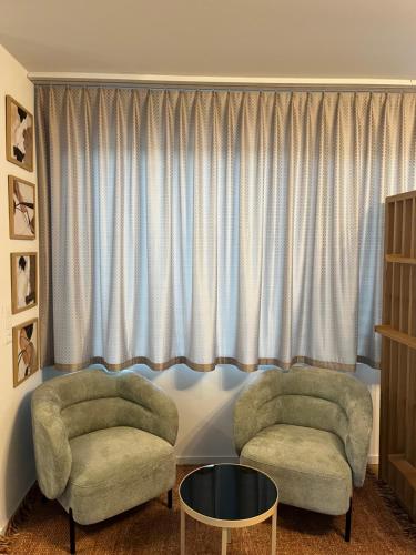 two chairs and a table in front of a window at Studio Horizon Dorigny in Lausanne