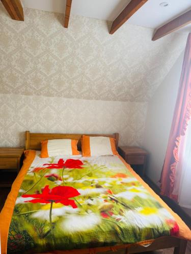 a bed with red flowers on it in a bedroom at Family apartment with pool & garden view in Mārupe