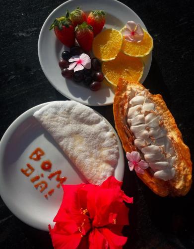 a plate of food with bread and fruit on a table at Eden One in Ilhéus