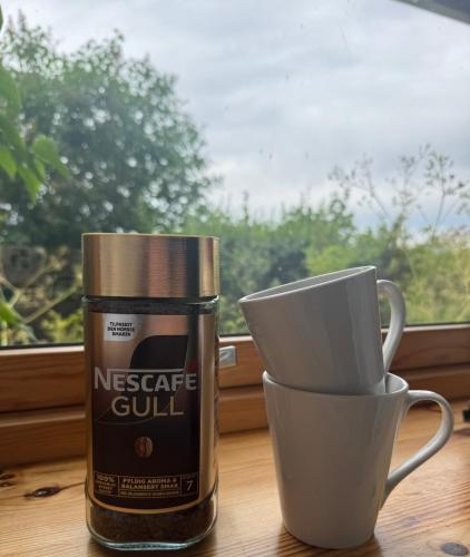 a container and cups sitting on a table next to a window at Linken Studio for 2 in Narvik