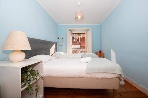 a blue bedroom with a bed and a lamp at Condessa Vintage Apt Chiado in Lisbon
