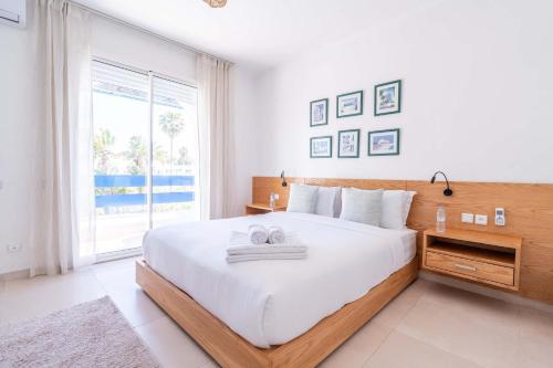 ein Schlafzimmer mit einem großen Bett und einem großen Fenster in der Unterkunft Villa in Golf Resort with Shared Pool in Bouznika