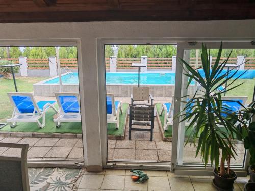 a screened in porch with chairs and a swimming pool at Vila Boba Bor in Zlot