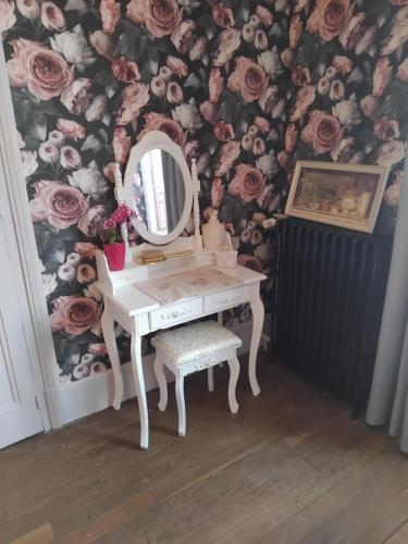 a dressing table with a mirror and a flower wall at Le jardin de Kristine in Vinneuf