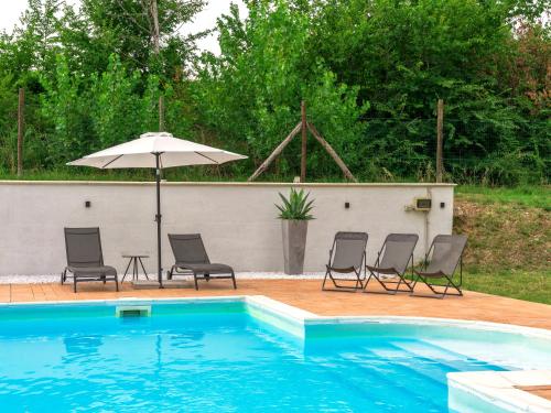 a group of chairs and an umbrella next to a pool at APPARTAMENTI CON PISCINA in Spoleto