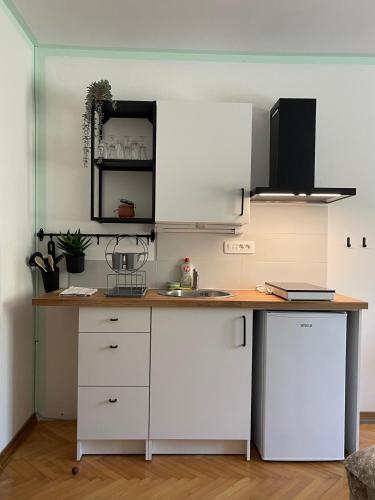 a kitchen with white cabinets and a wooden counter top at 4 Roses Residence in Sečovlje