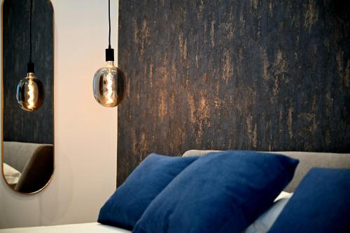 サレルノにあるOmnia Luxury Suiteの青い枕と鏡のあるリビングルーム